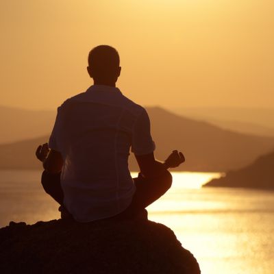Guy meditating at sunset