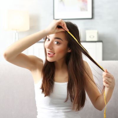 Young woman measuring hair